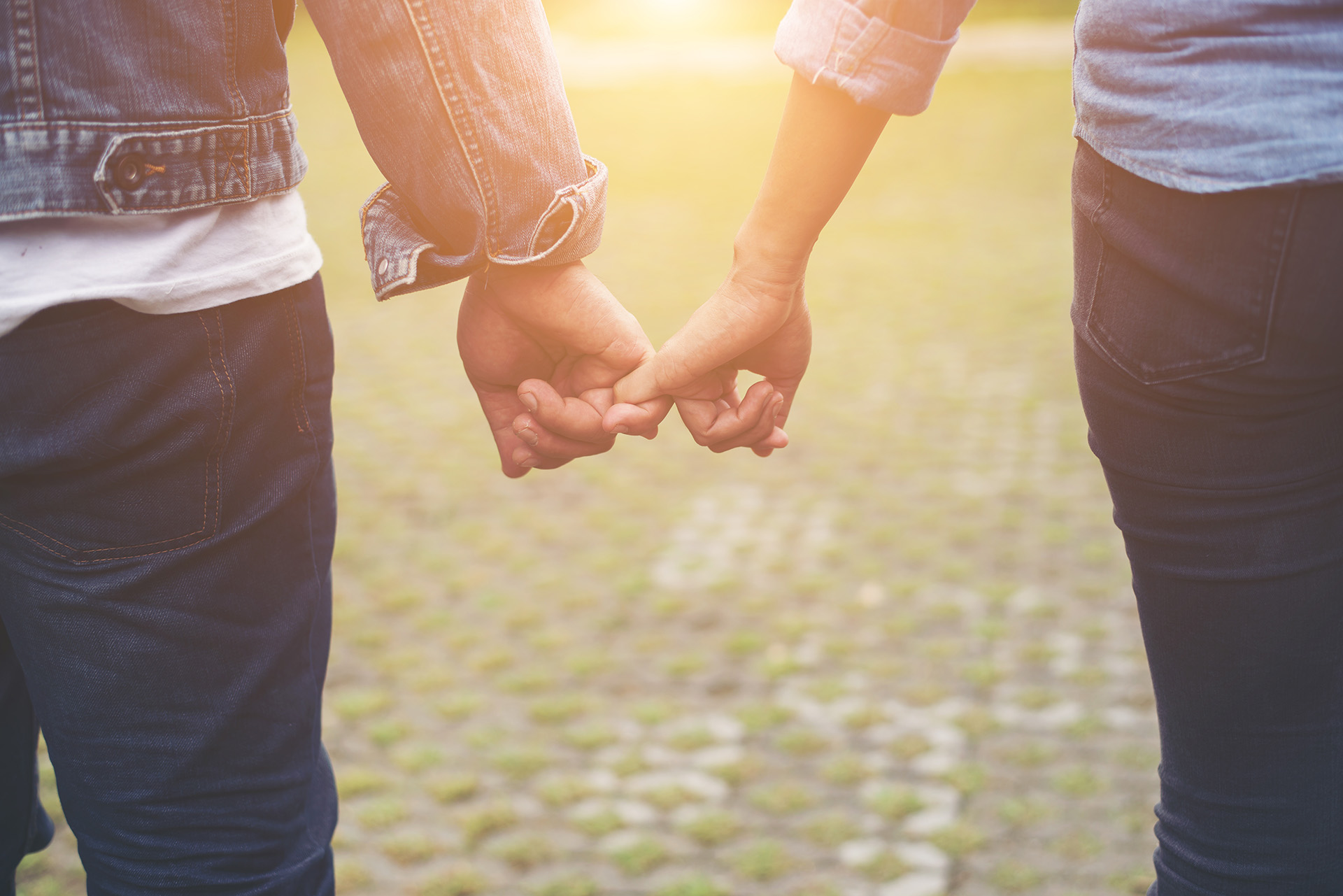 Close-up of loving couple holding hands while walking outdoor, C